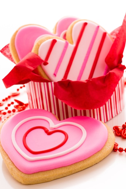 Galletas en forma de corazón decoradas con elegantes patrones de glaseado.