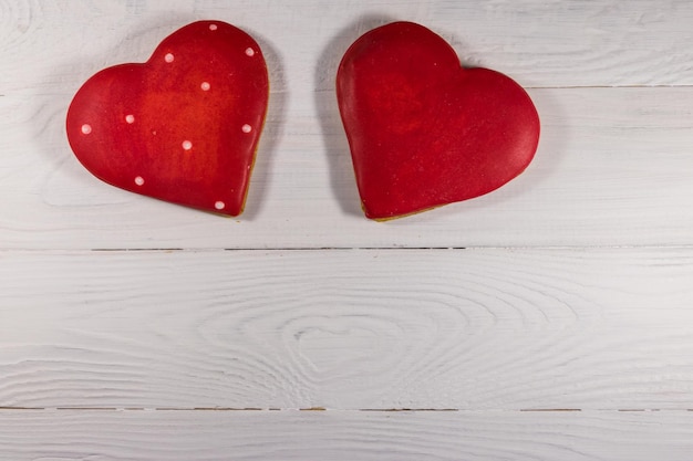 Galletas en forma de corazón para el día de San Valentín en mesa de madera blanca. Vista superior, espacio de copia