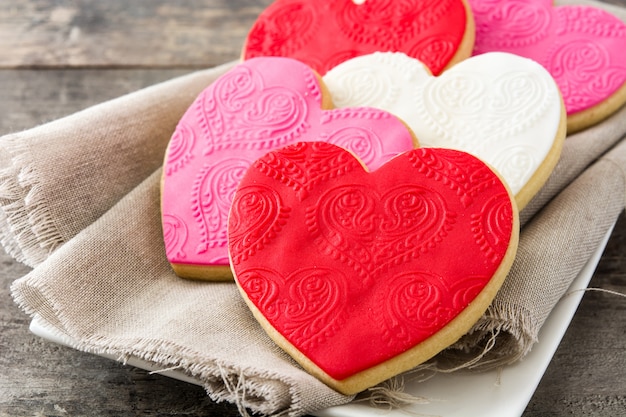 Galletas en forma de corazón para el día de San Valentín en la mesa de madera de cerca