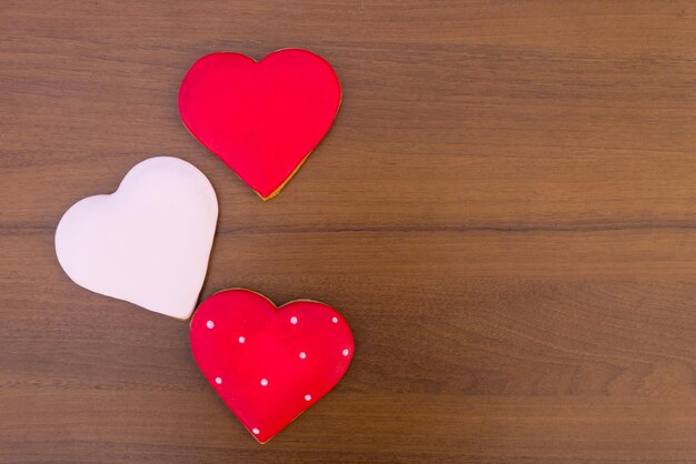 Galletas en forma de corazón para el día de San Valentín en mesa de madera. Vista superior