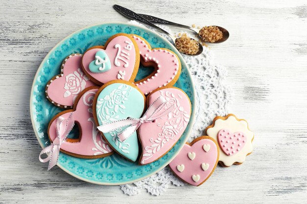 Galletas en forma de corazón para el día de san valentín en un plato, sobre fondo de madera de color