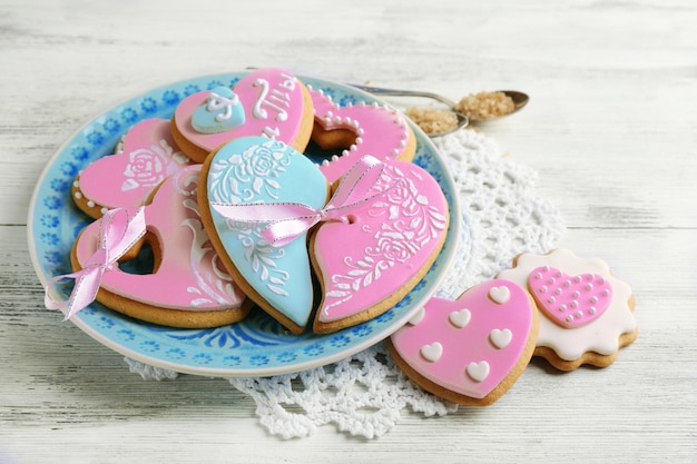 Galletas en forma de corazón para el día de san valentín en un plato, sobre fondo de madera de color