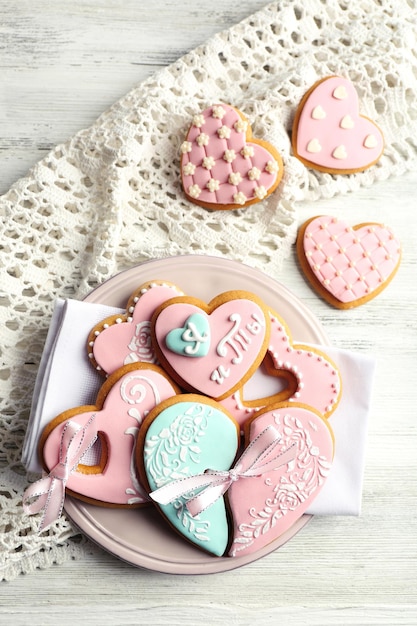 Galletas en forma de corazón para el día de san valentín en un plato, sobre fondo de madera de color