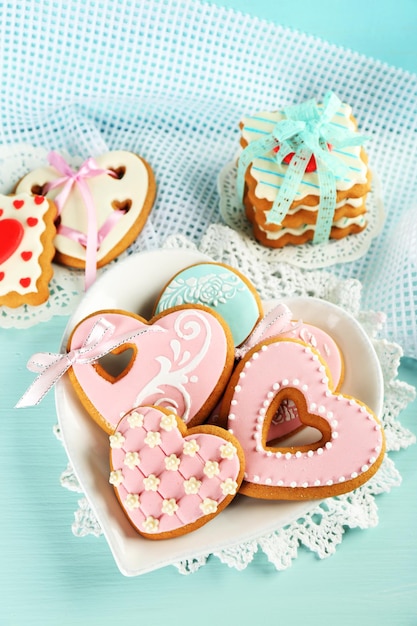 Galletas en forma de corazón para el día de san valentín en un plato, sobre fondo de madera de color