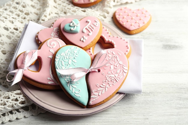 Galletas en forma de corazón para el día de san valentín en un plato, sobre fondo de madera de color