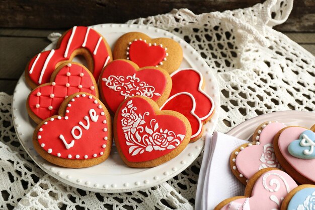 Galletas en forma de corazón para el día de san valentín en servilleta, sobre fondo de madera de color