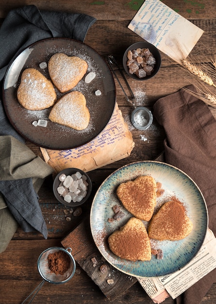 Galletas en forma de corazón espolvoreadas con cacao y azúcar en polvo. La vista desde arriba.