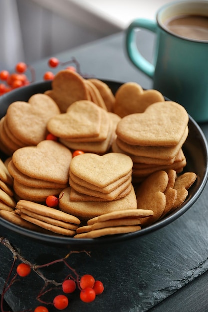 Galletas en forma de corazón y una taza de cacao en una mesa