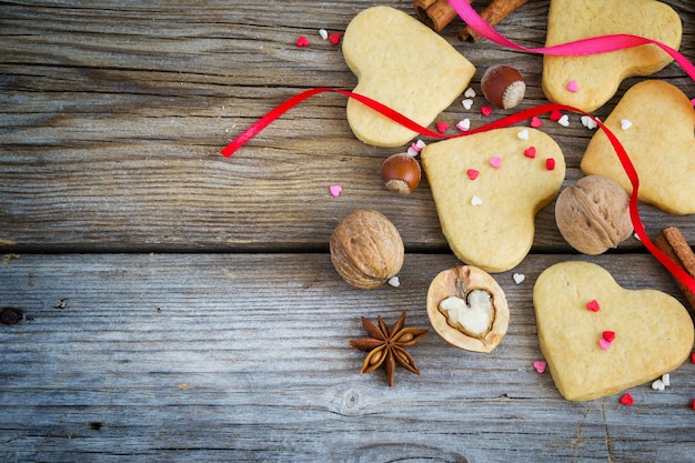 Galletas en forma de corazones, corazones de colores, cintas, canela y nueces.