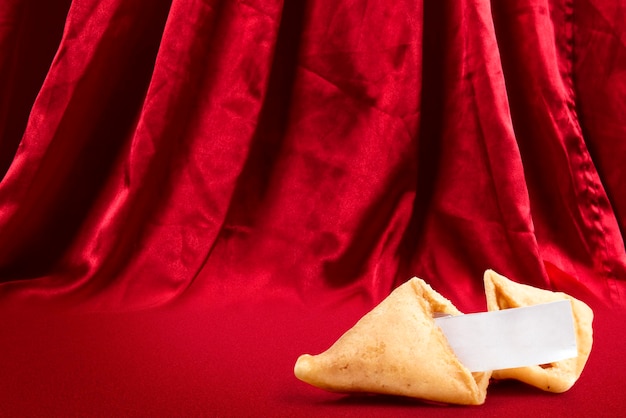 Galletas de la fortuna con una cita vacía con fondo de cortina roja. Feliz Año Nuevo Chino