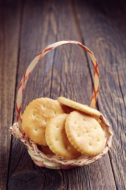 Galletas de galleta en una canasta de mimbre sobre fondo de madera oscura.