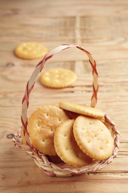 Galletas de galletas en una cesta de mimbre sobre una mesa de madera antigua