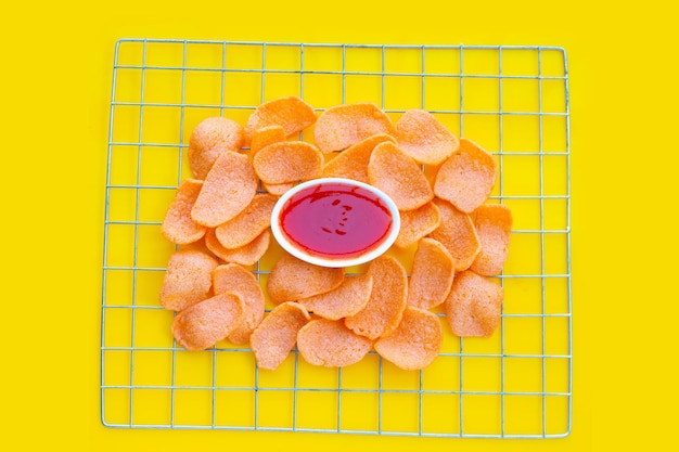 Galletas de gambas sobre fondo amarillo. Snack de arroz crujiente de gambas