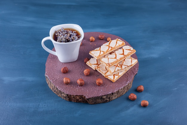 Galletas de gofres esparcidas con una taza de té de hierbas.