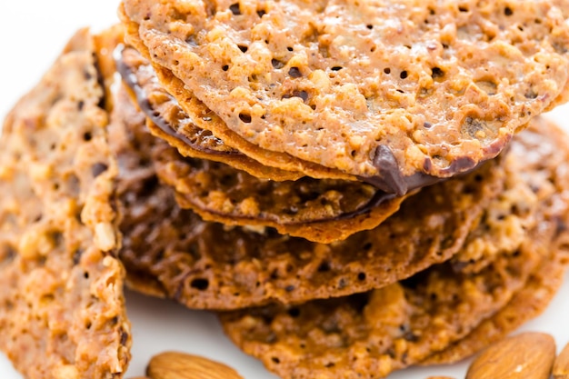 Foto galletas gourmet de encaje de almendras emparedadas con chocolate.