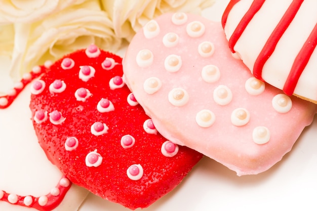 Galletas gourmet con ramo de rosas blancas.