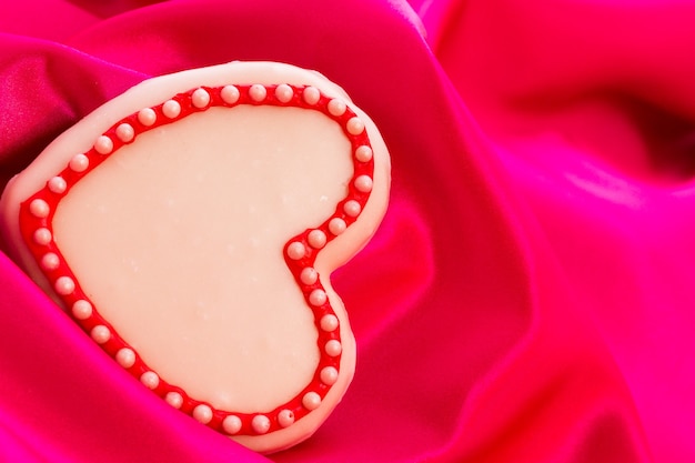 Galletas Gourtmet en forma de corazón decoradas para San Valentín en seda rosa.