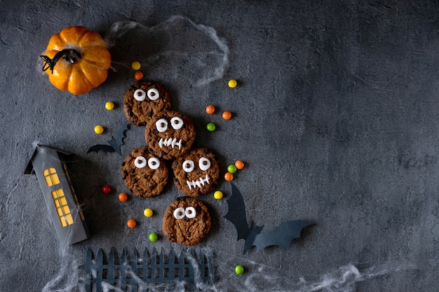 Galletas de Halloween. Monstruos divertidos hechos de galletas con chocolate sobre la mesa. Decoración de fiesta de Halloween. Concepto de truco o trato.