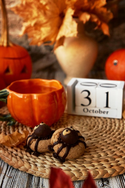 Foto galletas de halloween de otoño estéticas tradicionales en forma de araña y taza de té en forma de calabaza 31 de octubre en el calendario