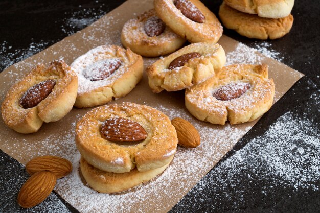 Galletas hechas en casa con las almendras en un fondo oscuro.