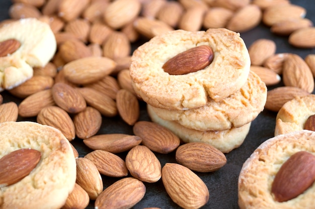 Foto galletas hechas en casa con las almendras en un fondo oscuro.