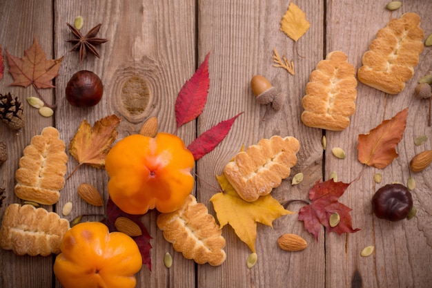 Galletas y hojas de otoño en madera