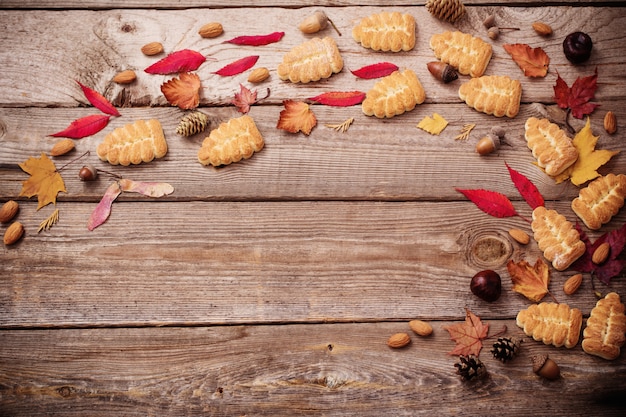 Galletas y hojas de otoño en la pared de madera