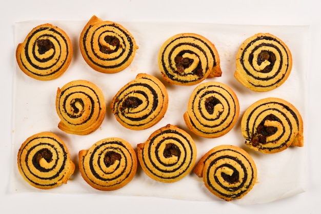 Galletas horneadas con pasas y semillas de amapola aisladas sobre fondo blanco.