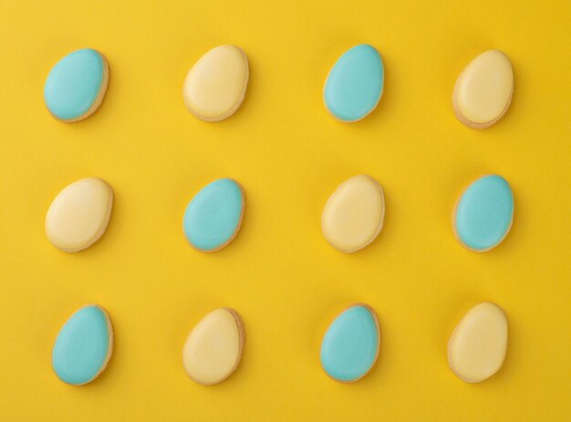 Galletas de huevo de Pascua azules y amarillas sobre fondo amarillo.