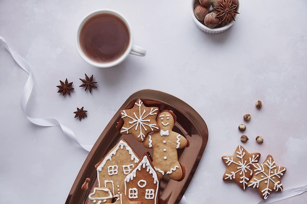 Galletas de jengibre atmosféricas de temporada con una taza de anís estrellado de cacao y avellanas planas