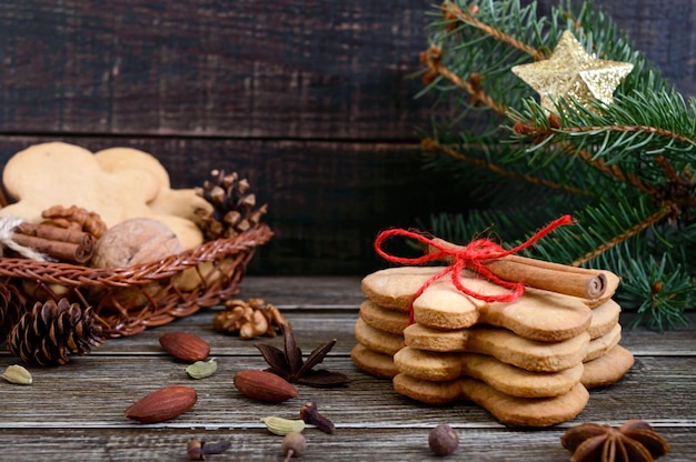 Galletas de jengibre caseras de Navidad y especias en el fondo de madera