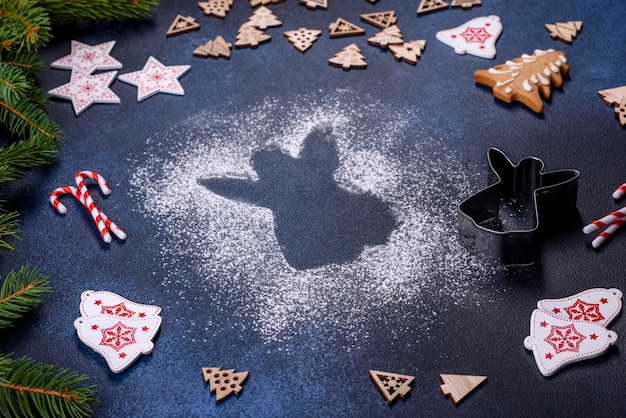 Galletas de jengibre caseras de Navidad en una mesa de hormigón oscuro