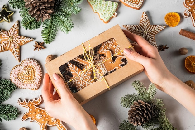 Galletas de jengibre caseras navideñas en una caja de regalo sobre una mesa gris