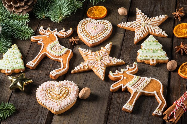 Galletas de jengibre caseras navideñas y especias en mesa de madera