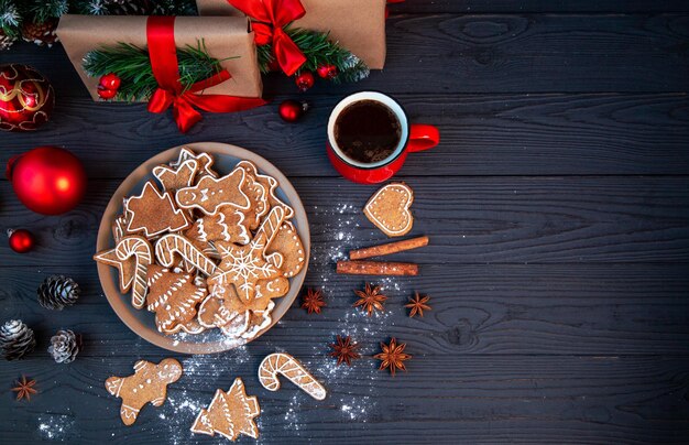 Galletas de jengibre caseras tradicionales y una taza de café entre la decoración navideña Ambiente navideño de vacaciones