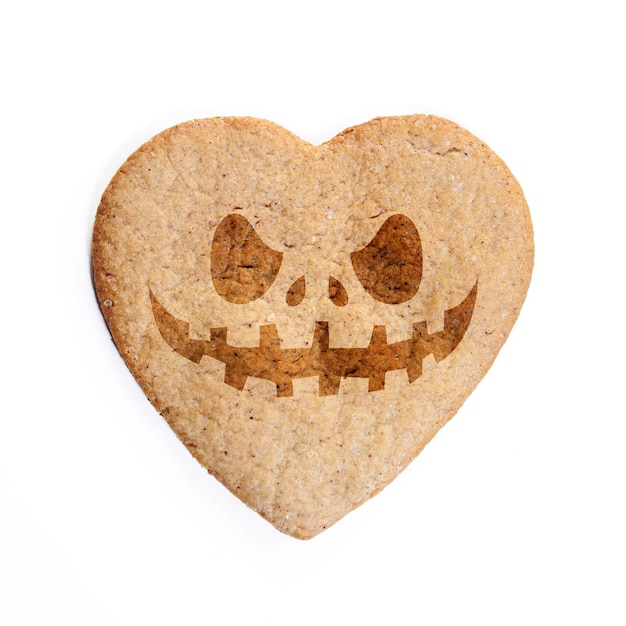 Foto galletas de jengibre en forma de corazón con cara de halloween aislada