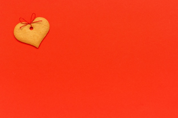 Galletas de jengibre en forma de corazón decoradas con un lazo en rojo