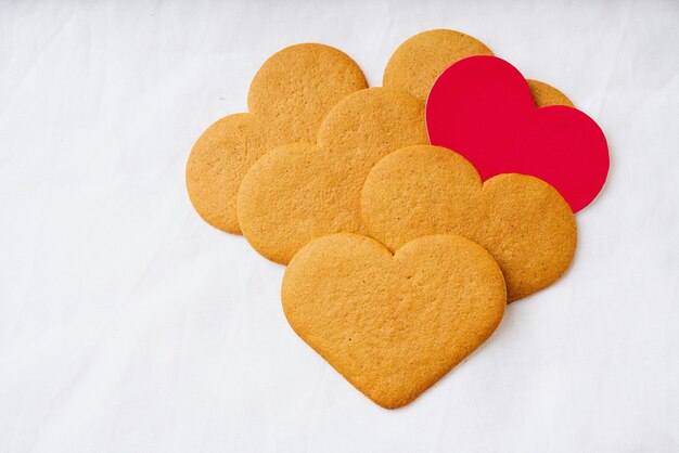 Galletas de jengibre en forma de corazón con tarjeta roja. Copie el espacio.