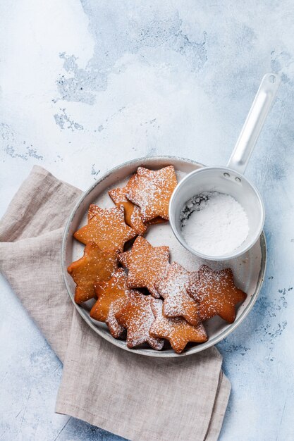 Galletas de jengibre de forma de estrella de Navidad caseras en placa de cerámica sobre superficie gris de hormigón viejo. Vista superior