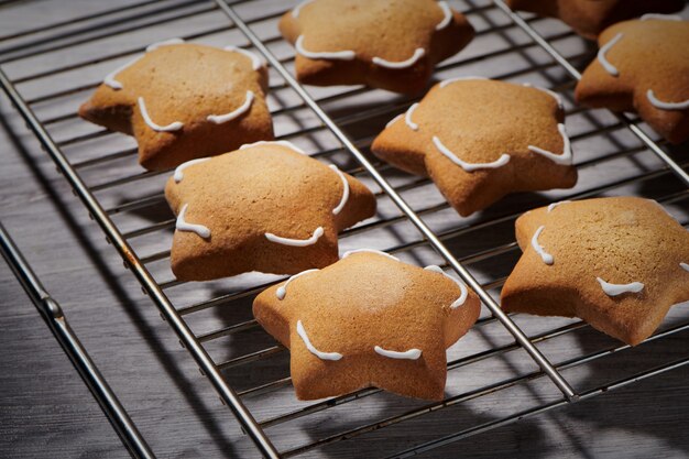 Galletas de jengibre en forma de estrella recién horneadas en rejilla de enfriamiento. Primer plano, vista de enfoque selectivo