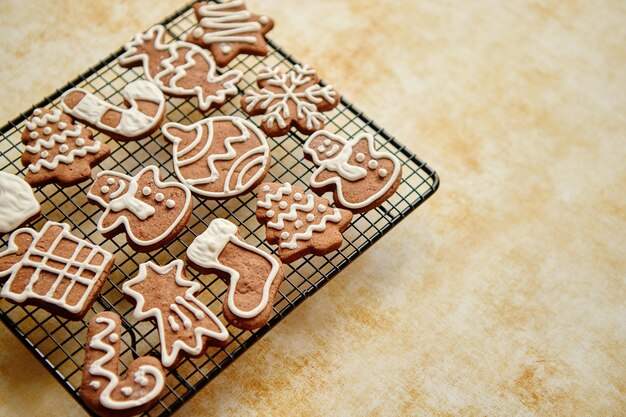 Galletas de jengibre con forma de Navidad recién horneadas y preparadas colocadas sobre un marco de parrilla de acero sobre una mesa Vista desde arriba