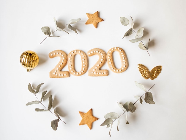 Galletas de jengibre en forma de números y galletas de jengibre de año nuevo 2020 y marco de decoración de Navidad
