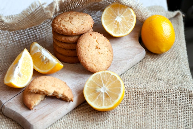 Las galletas de jengibre y limón yacen sobre una tabla de madera sobre una mesa rústica