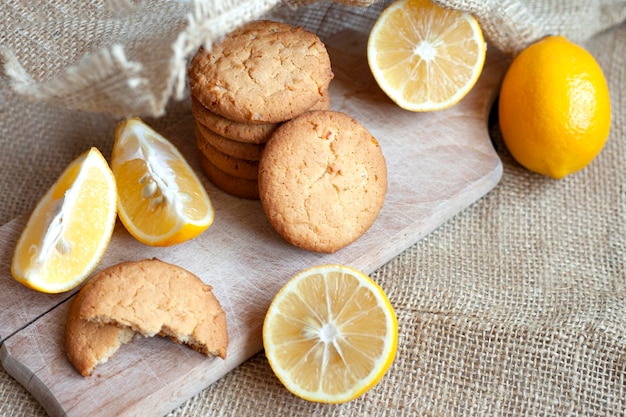 Las galletas de jengibre y limón yacen sobre una tabla de madera sobre una mesa rústica