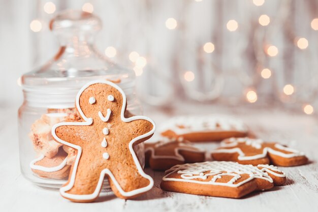 Galletas de jengibre en una mesa y luces de Navidad en el fondo