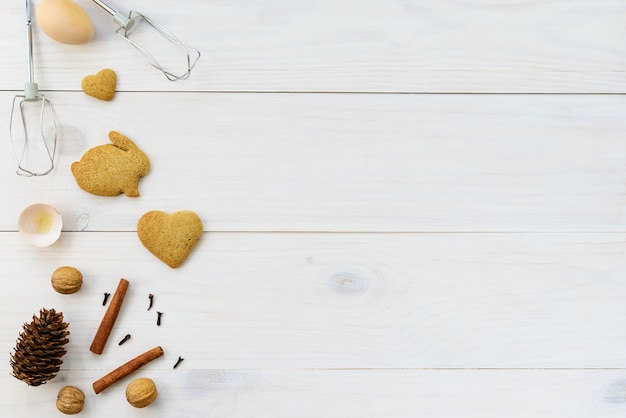 Galletas de jengibre en una mesa de madera blanca.