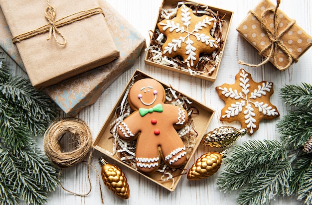 Galletas de jengibre de Navidad en cajas de cartón sobre mesa de madera blanca