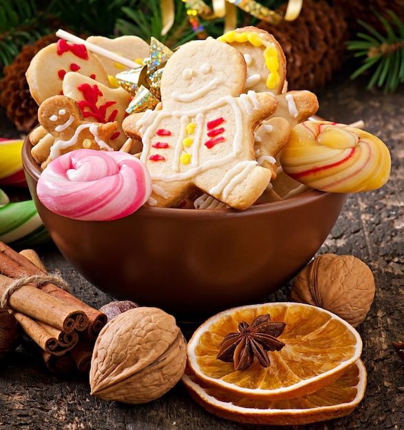 Galletas de jengibre de Navidad y piruletas sobre fondo de madera vieja