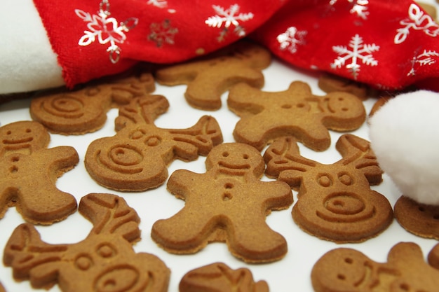 Galletas de jengibre de Navidad y sombrero rojo de Santa Claus aislado sobre un fondo blanco. De cerca