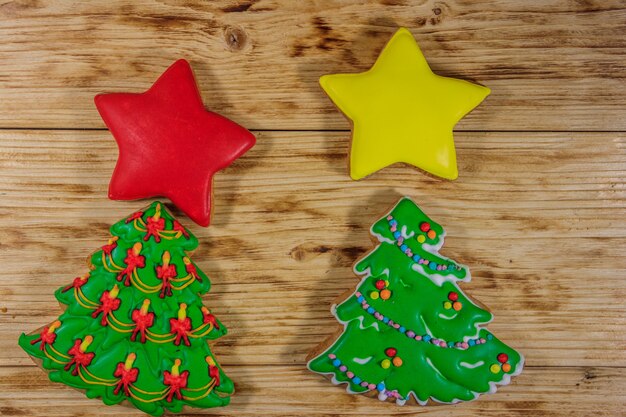 Galletas de jengibre navideñas festivas en forma de árbol de Navidad y estrellas en la mesa de madera. Vista superior
